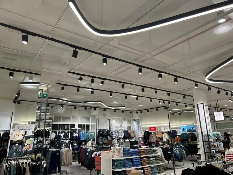 Satış alanında ray spot aydınlatma ve kıvrımlı lineer armatür