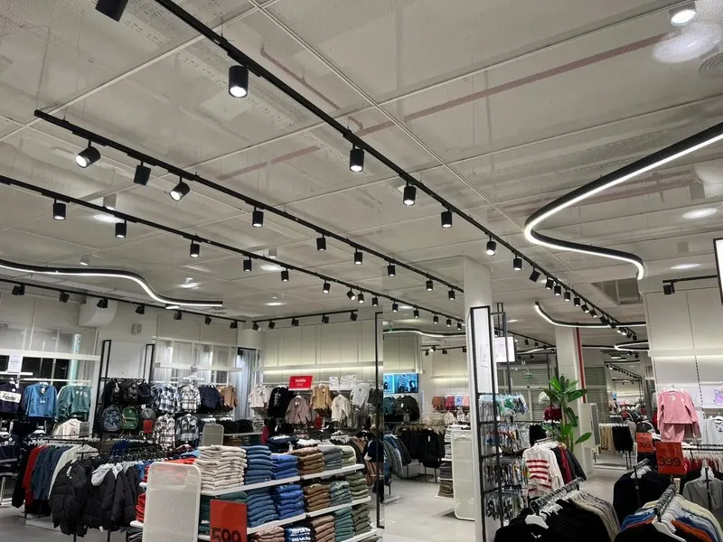 Satış alanında ray spot hatları ve kıvrımlı lineer armatürler